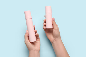 Female hands with cosmetic products on color background, closeup