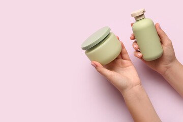 Female hands with cosmetic products on lilac background, closeup