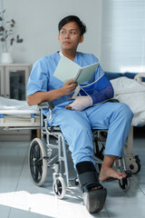 Young patient reading notes in wheelchair after accident