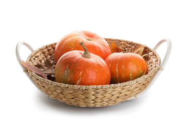 Wicker basket with fresh pumpkins on white background