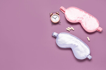 Stylish sleep masks, pills and alarm clock on color background