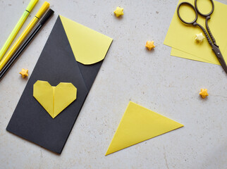 Handmade Crafting Process of a DIY Greeting Card with Origami Paper Hearts, Glue Application, Creative Stationery, Scissors, and Colorful Decorative Elements on a Light Artistic Background