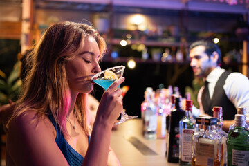 Asian beautiful woman having fun drinking cocktail in bar restaurant. 