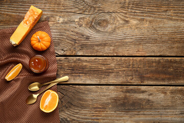 Jar of sweet pumpkin jam with orange on wooden background