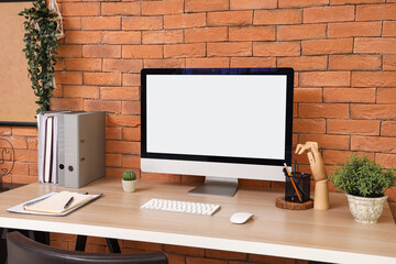 Fototapeta premium Blank computer monitor with folders on table in office