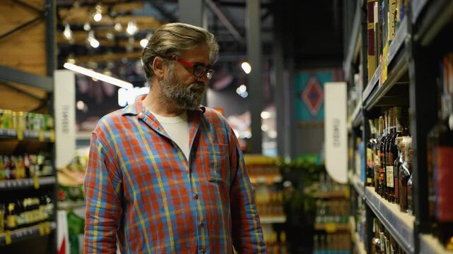 Senior man buying discounted cognac in a liquor store