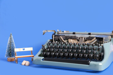 Vintage typewriter with Christmas decor on blue background