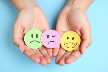 person holding a smiley face in their hands