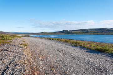 Gravel road along the bay of Barents Sea. Rybachy Peninsula, Murmansk region, Russia