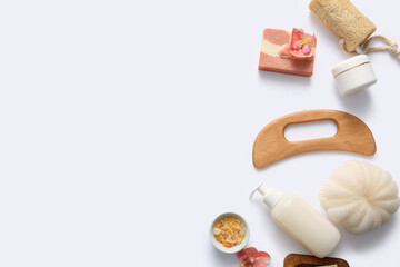Beautiful composition with wooden guasha body massage tool and bath supplies on white background