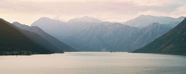 Majestic mountains by peaceful lake under clouds