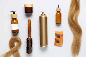Hair spray with cosmetics, comb, brush and strands on white white background