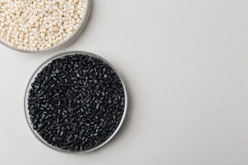 Colorful plastic granules in petri dishes on gray background, flat lay. Space for text