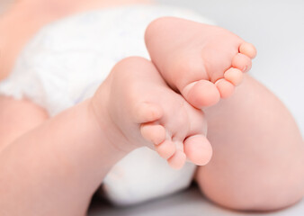 tiny feet of a baby lying on his tummy, close-up