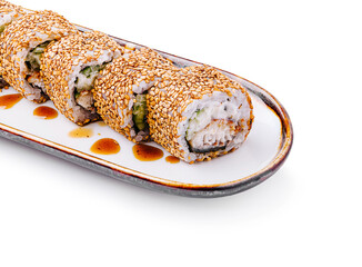 Sushi rolls with sesame seeds and sauce on a white plate