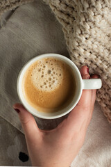 Woman holding foamy mug of espresso