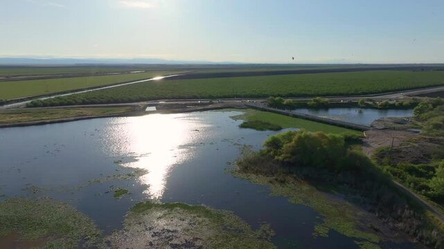 Aerial view sun reflects off water at Fresno Slough canals