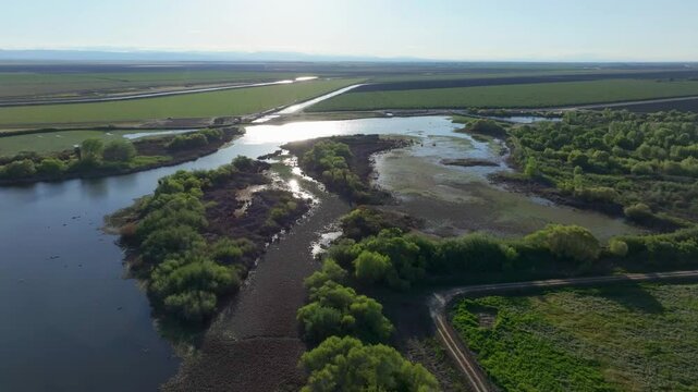 Wide aerial sun reflects off Fresno Slough water rivers