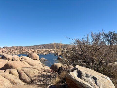 Rocky desert landscape overlooking Watson Lake under a clear blue sky