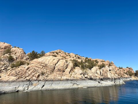 Rocky shoreline, rugged cliffs, calm waters of Watson Lake