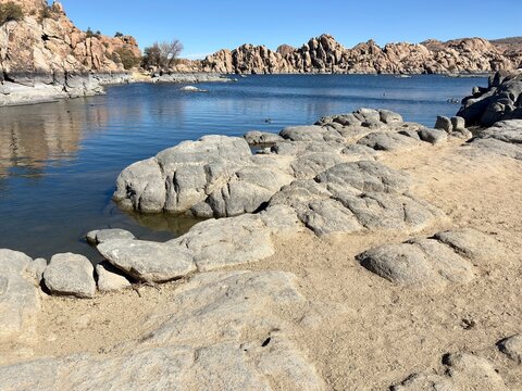 Rocky shoreline and sandy terrain at Watson Lake in Prescott, Arizona