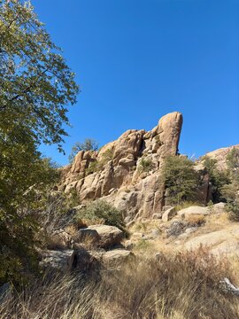 Towering rock formations with dry grass & green vegetation