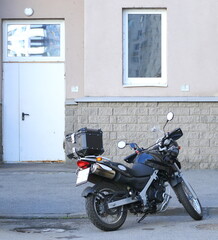 A motorcycle is parked near the entrance to the building, Soyuz Prospekt, Saint Petersburg, Russia, June 28, 2024