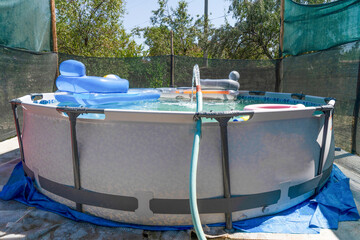 Blue plastic pool in the garden.