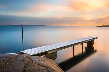 Snow covered jetty at sunset near Gothenburg creating a tranquil winter landscape