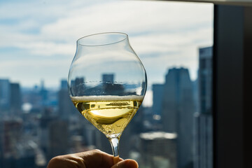 ホテルの高層階でワイングラスを傾ける