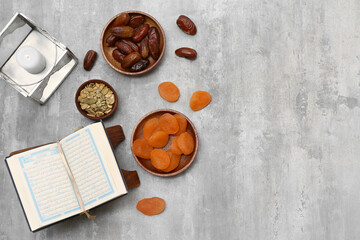 Koran, Muslim lamp, dates and dried apricots on grey grunge background. Ramadan celebration