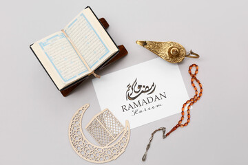 Greeting card, prayer beads, Aladdin lamp and Koran on grey background. Ramadan celebration
