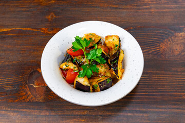 Colorful vegetable dish served in a white bowl on wooden table