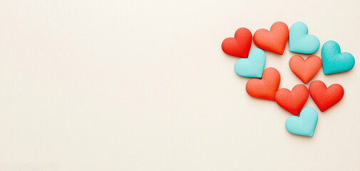 Obraz premium Colorful heart-shaped decorations in red and turquoise arranged artistically on a light background, evoking feelings of love and affection.