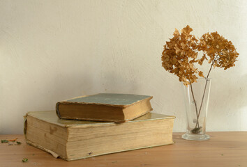 Vintage books and dried flowers on wooden table