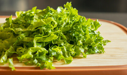  fresh sliced chopped lettuce on a wooden cutting board close-up