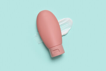 Bottle of cosmetic product with sample on color background