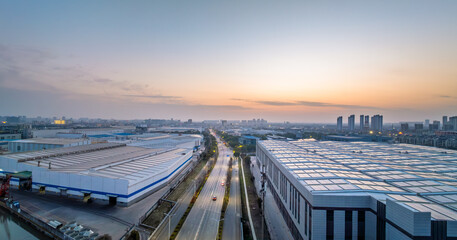 Aerial view of modern industrial park and cityscape at sunset