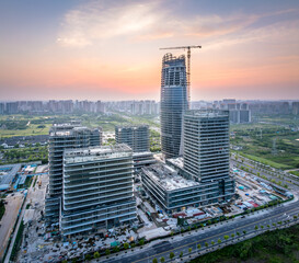 Modern office buildings and skyscraper under construction at dusk