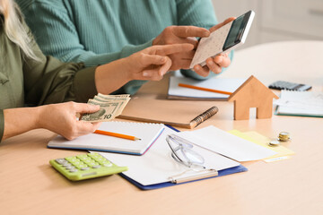 Senior man with his wife calculating utility bills in kitchen, closeup