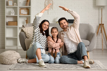 Happy couple with adopted girl making roof gesture at home