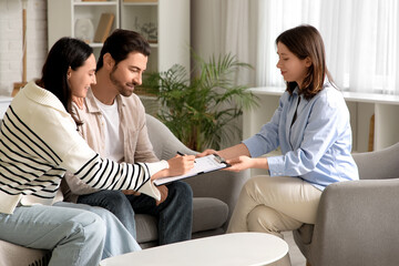 Happy couple with social worker filling out application for adoption of child at home