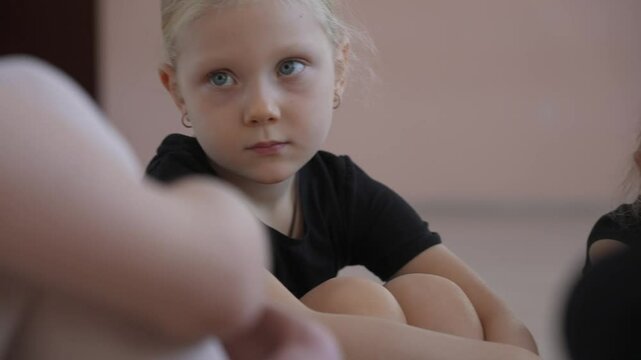 Children's ballet school. Caucasian woman teaching ballet to little girls. 
