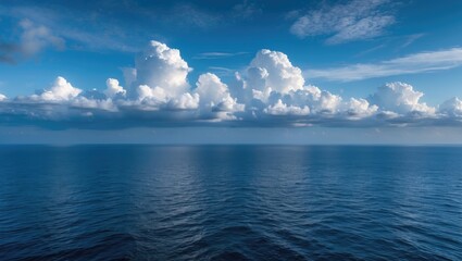 Fototapeta premium Tranquil Ocean Horizon with Blue Skies and Dramatic Clouds Reflecting on Calm Waters