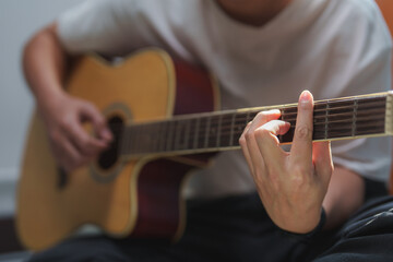Fototapeta premium Musician playing acoustic guitar, practicing chords and melodies