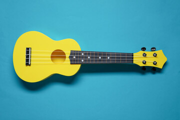 One ukulele on light blue background, top view