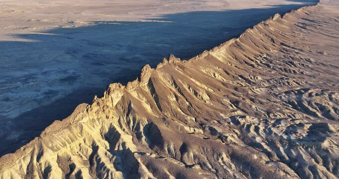 A slow-rising drone shot of one of the &ldquo;dikes&rdquo;, a long and thin ridge, flanking out from the monolithic &ldquo;Ship Rock&rdquo;, and the unique terrain formed by what used to be an active volcano in New Mexico.