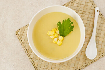 Creamy corn soup in ceramic bowl on the table. Vegetarian food

