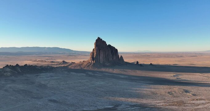 An unworldly high and far, wide-angle aerial shot of the sacred &ldquo;Ship Rock&rdquo;, a massive, monolithic monadnock, towering above the high desert plain of the Navajo Nation, in New Mexico, United States.