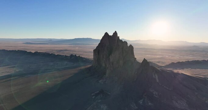 An unworldly, high-flying drone shot of the sacred &ldquo;Ship Rock&rdquo;, a massive, monolithic rock butte, towering above the high desert plain of the Navajo Nation, in New Mexico, as the sun sets behind.